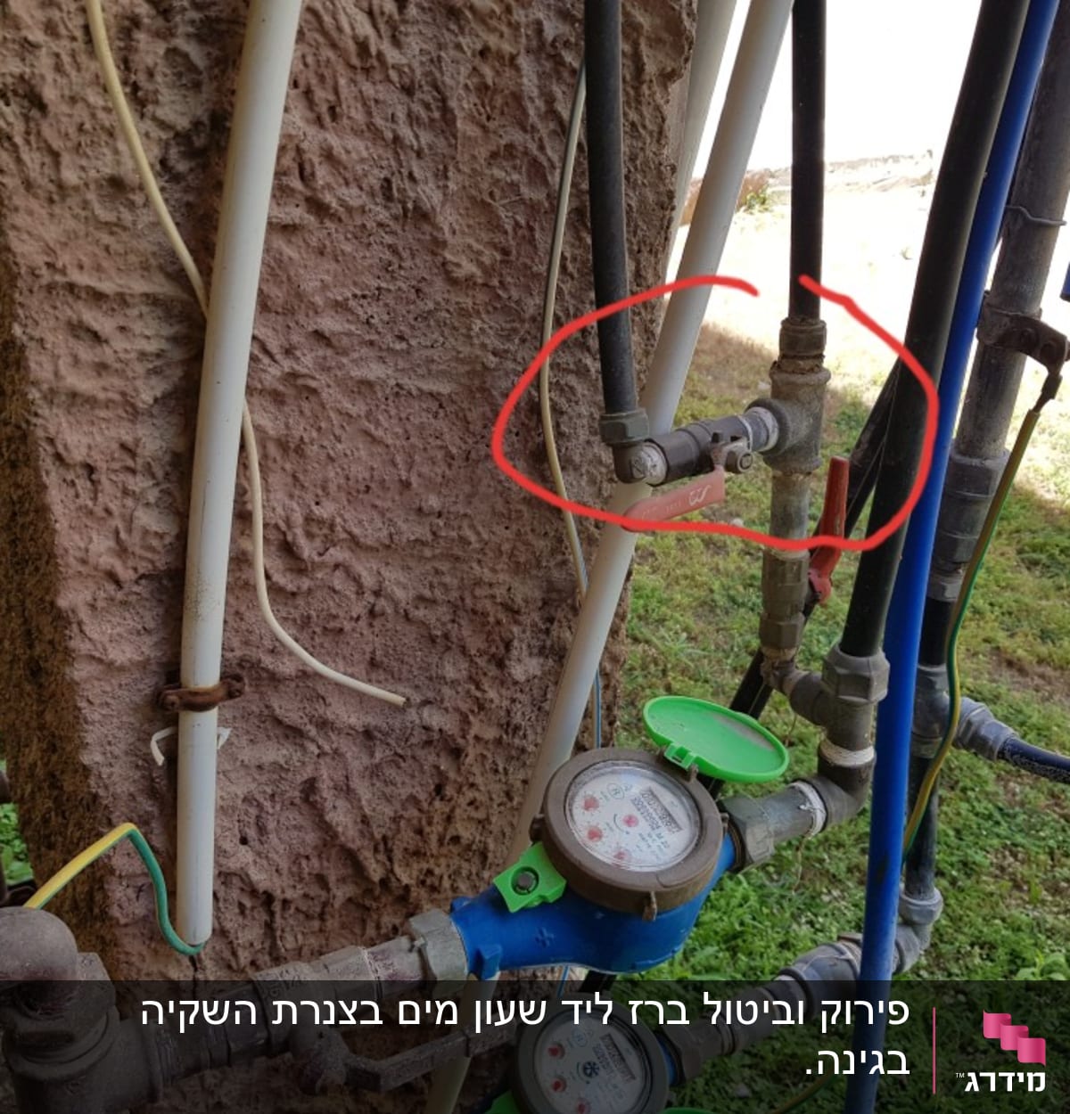 צינורות מים עם ברזים ומדי מים מחוברים לקיר